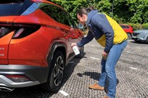 Luke Wilkinson applies a spray to a car ready for a photoshoot