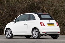 Fiat 500C (2023) review: rear three quarter static, white car, wood in background