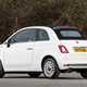 Fiat 500C (2023) review: rear three quarter static, white car, wood in background
