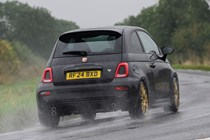 Abarth 695 (2024) review: rear three quarter cornering, rain, black paint