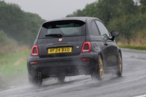 Abarth 695 (2024) review: rear three quarter cornering, rain, black paint