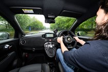 Abarth 695 (2024) review: interior driving, Luke Wilkinson at the wheel, black upholstery