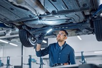 What is a car service plan? Technician checking underside of vehicle