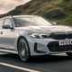 Best estate cars 2024: BMW 3 Series Touring, front three quarter driving, silver paint, British road