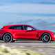 Best estate cars 2024: Porsche Taycan Sport Turismo, side view driving, red paint, British road