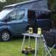 The two Ryobi camping tools near a campervan