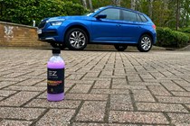 The bottle of EZ Car Care shampoo next to a blue car