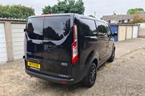Ford Transit Custom Trail DCIV long-term test review, rear view, Shadow Black, parked in front of garages, low