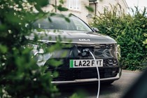 Kia Niro EV charging behind a bush