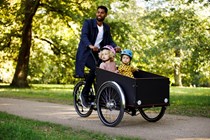 a man and two children in a cargo bike