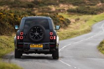 Land Rover Defender 130 V8 review: rear three quarter cornering, British B-road, low angle, black paint