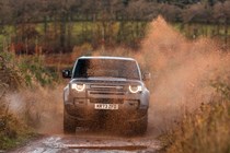 Land Rover Defender 130 V8 review: front off-roading, big water splash, black paint