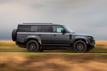 Land Rover Defender 130 V8 review: side view driving, British B-road, black paint