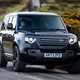 Land Rover Defender 130 V8 review: front three quarter cornering, British B-road, low angle, black paint