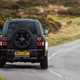 Land Rover Defender 130 V8 review: rear three quarter cornering, British B-road, low angle, black paint