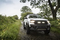 Ford Ranger M-Sport review - white, front view, lights on, driving along country lane