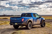Ford F-150 Raptor review - blue, rear view, parked off-road in the UK, muddy