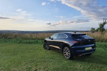 Jaguar I-Pace shot from the rear, looking out onto a country vista