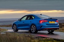 Skoda Octavia in blue, shot of the rear with lights on against a cloudy sunset