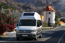 VW Grand California camper review - front view, driving past windmill, white and beige