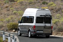 VW Grand California camper review - rear view, driving round corner, white and beige