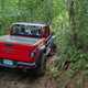 Jeep Gladiator review - red, driving around tight muddy corner, off-road