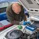 Bonnet open with battery in clear view, tools laid out on the wing or scuttle panel Alt text: Open bonnet with car battery visible and tools ready for replacement - how to change a car battery