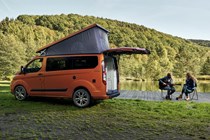 Ford Transit Custom Nugget campervan - rear view, orange, parked by lake with tailgate open