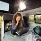 Ford Transit Custom Nugget campervan - lower sleeping area, woman on laptop