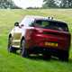 How to drive off-road: Range Rover Sport, driving on grass, rear three-quarter view, red paint