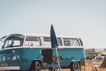VW camper next to some camping chairs