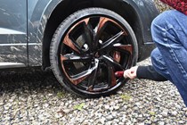 Aaron Hussain uses a microfibre barrel brush to clean an alloy wheel.