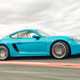 Turquoise 2020 Porsche 718 Cayman front three-quarter driving