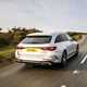 Image of a silver Mercedes E-Class estate, driving, from the rear right corner
