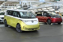 VW electric cars - ID. Buzz, yellow and white, leaving production line, beside VW Multivan (black and red) and in front of many VW Transporter vans
