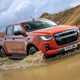 Best pickup trucks UK: Isuzu D-Max, front, orange, wading through deep muddy water