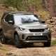 Best luxury SUVs - Land Rover Discovery, front view, driving off road on forest track