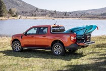 Ford Maverick pickup truck, rear view, orange, loaded with kayak