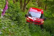 Iveco Daily 4x4 All-Road panel van, red, front view, driving down extremely over-grown track
