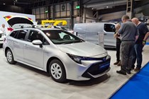 Toyota Corolla Commercial Hybrid Electric van at the 2021 CV Show, front view with people looking at the spec