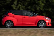 Best small hybrid cars 2024: Toyota Yaris side view driving, red paint