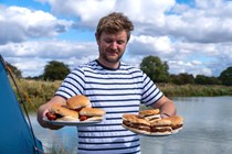 Adam proudly displaying his vegan burgers and sausages