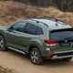 Subaru Forester (2022) review - rear pan shot, green car, driving along a dirt road