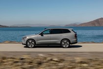 Volvo EX90 review: side view driving, grey paint, water in background