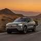 Volvo EX90 review: front three quarter driving, grey paint, desert in background, sunset