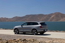 Volvo EX90 review: rear three quarter static, grey paint, lake in background