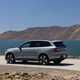 Volvo EX90 review: rear three quarter static, grey paint, lake in background