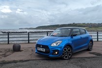 Suzuki Swift Sport long termer front three quarter, parked by the shore