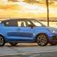Suzuki Swift Sport (2023) review: front three quarter static, blue car, sunset beach background