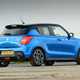 Suzuki Swift Sport (2023) review: rear three quarter static, blue car, wood in background